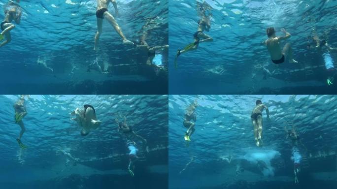一群游客在阳光下的珊瑚礁旁边的酒店码头玩得开心。度假者在珊瑚旁边的海里游泳。水下射击