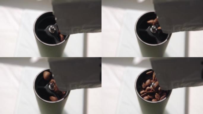 咖啡师用新鲜烘焙的咖啡豆填充手动研磨机。高品质阿拉比卡咖啡豆。