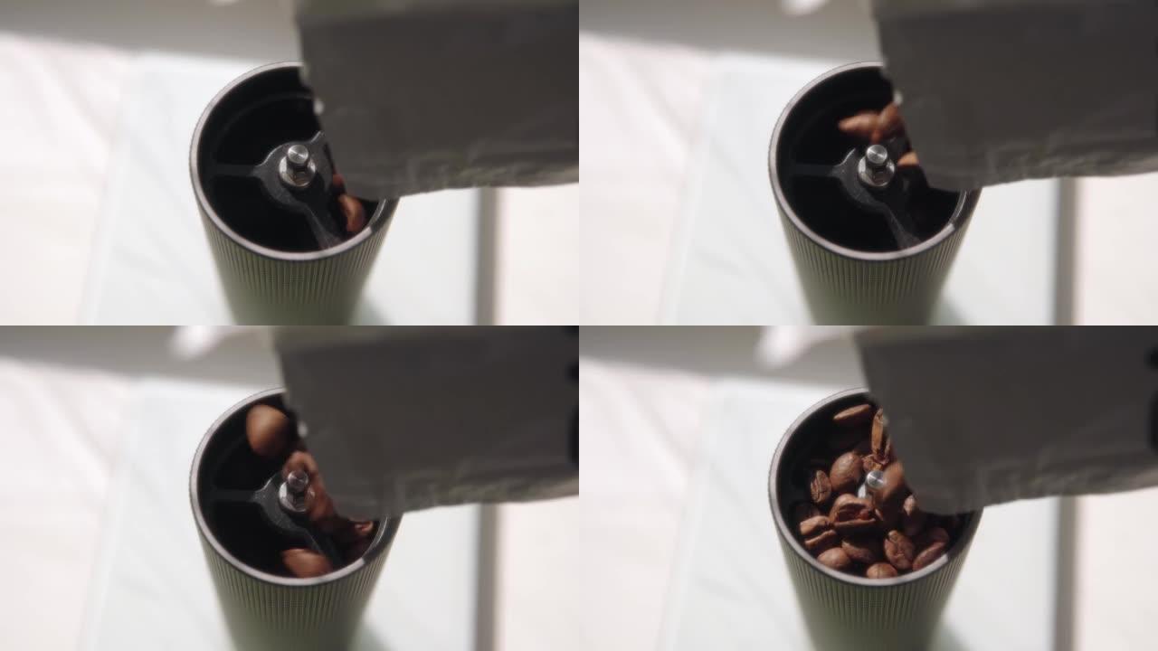 咖啡师用新鲜烘焙的咖啡豆填充手动研磨机。高品质阿拉比卡咖啡豆。