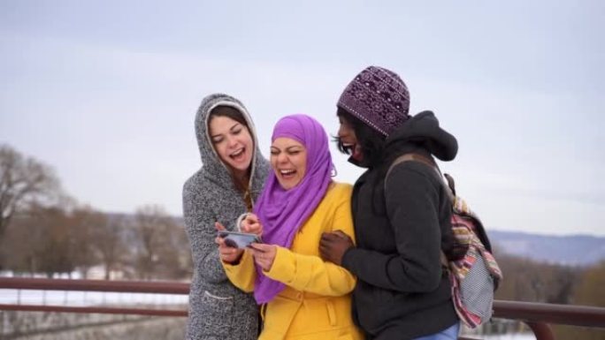 Multi-ethnic female friends looking at phone and l