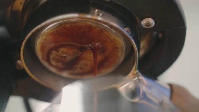 咖啡从机器滴入杯子。