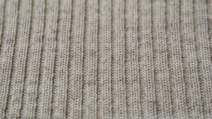 米色针织面料质地。特写细节毛衣面料背景。冬季时尚背景柔软羊毛纺织图案