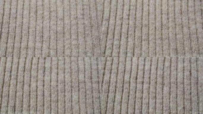 米色针织面料质地。特写细节毛衣面料背景。冬季时尚背景柔软羊毛纺织图案