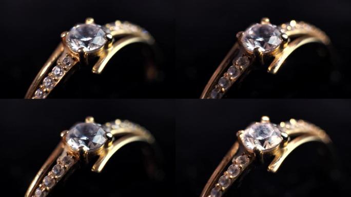 一颗耀眼的圆钻石镶在戒指上。在黑色背景上。特写俯视图