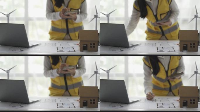 一位亚洲女工程师计划建造一座带有风力涡轮机和太阳能电池板的发电厂，这是一种电力概念。