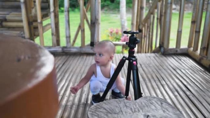 可爱的小宝贝开始好奇，在家玩相机三脚架。
