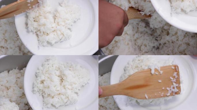 陶瓷盘子上的茉莉花米饭特写，用饭勺从锅里舀米饭