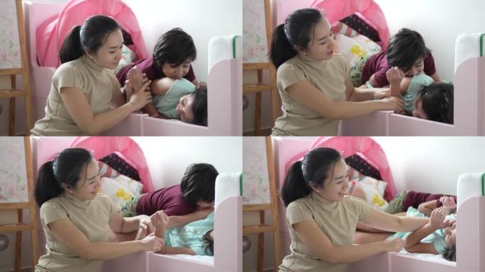 儿童发展 -- 亚洲华裔妇女在卧室里给她的双性恋儿童读书