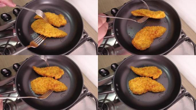 一个女人用叉子在煎锅里变成鸡