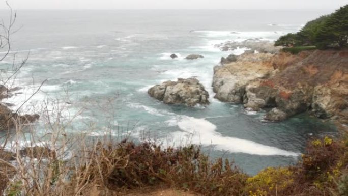 岩石崎岖的海洋，有雾的天气。海浪冲击海滩。加利福尼亚，大苏尔。