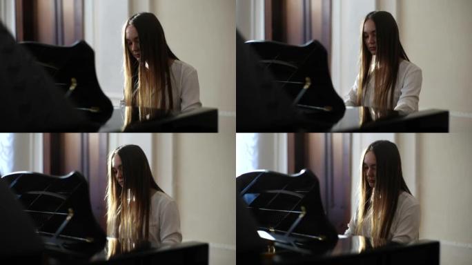 上课时，年轻才华横溢的女钢琴家穿着优雅的休闲服在轻教室里演奏钢琴温柔的古典音乐的跟踪镜头。