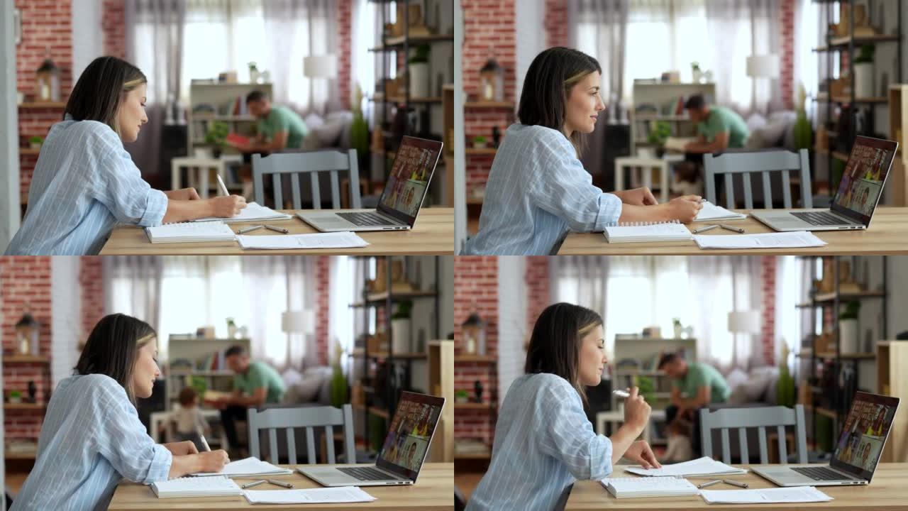 妇女在家时在笔记本电脑上进行在线学习。