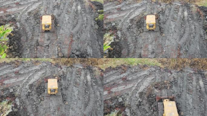 黄色推土机在建筑工地平整地面的鸟瞰图。重型平地机耙土。准备表面的无人机视图