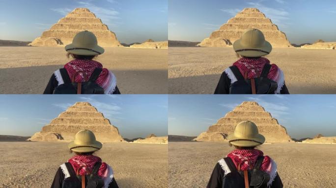 站在萨卡拉阶梯金字塔前的女人的后视图。