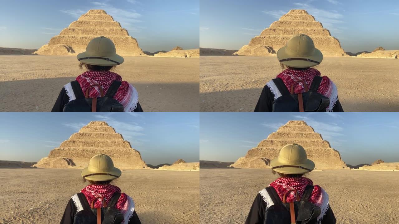 站在萨卡拉阶梯金字塔前的女人的后视图。