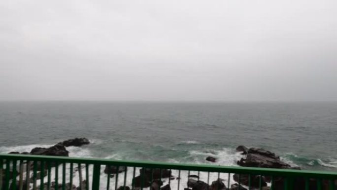 在台风日，沿着海边的道路行驶，看着大海。