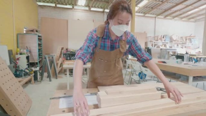 女木工工人在细木工制造的桌子上有一些纸制品和图纸。木制品设计与工艺生产理念