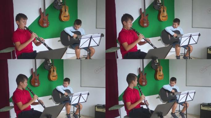 儿童在音乐学校用吉他和单簧管组成小型二重奏