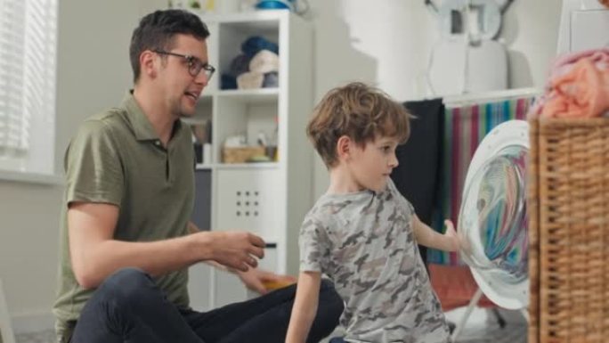 Father spends time with young children in laundry 