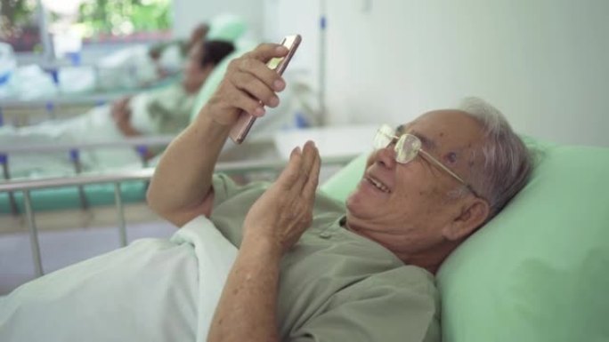 在医院疗养院的视频电话会议上，快乐的老年亚洲患者或养老金领取者与家人交谈的肖像。高级生活方式活动。退