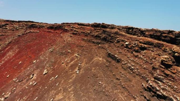 飞越一个巨大的火山口的斜坡。富埃特文图拉岛上的卡尔德隆洪多火山。红色干燥的贫瘠无生命的岩石土壤类似于