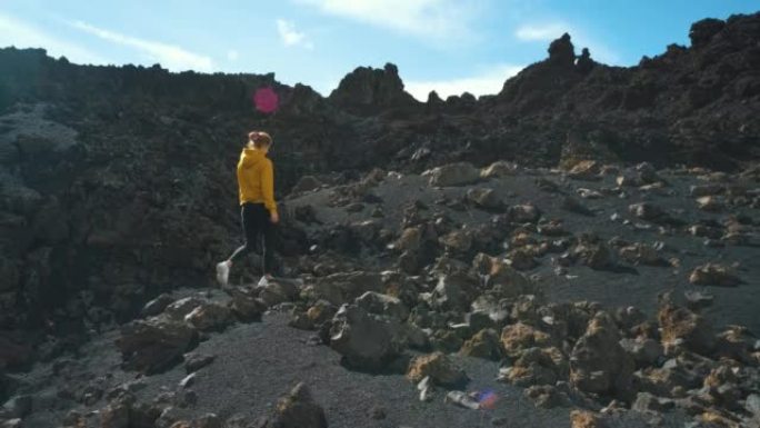 女旅行者在特内里费岛泰德国家公园的钦耶罗火山周围的熔岩田野中漫步。去任何地方。另一个星球的表面。