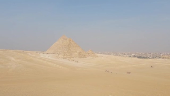 吉萨金字塔建筑群在埃及很远的地方。广角沙漠，蓝天。