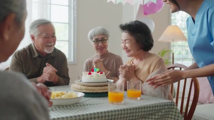 老年日托的生日派对，一群亚洲女性老年男性女性笑在养老院老年日托中心的生日朋友派对上的积极对话问候