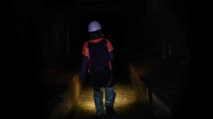 带手电筒的女挖掘机探索隧道