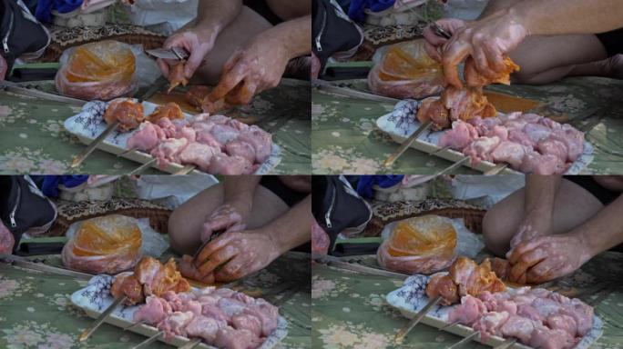 男性手切腌制的肉，用于烤肉串