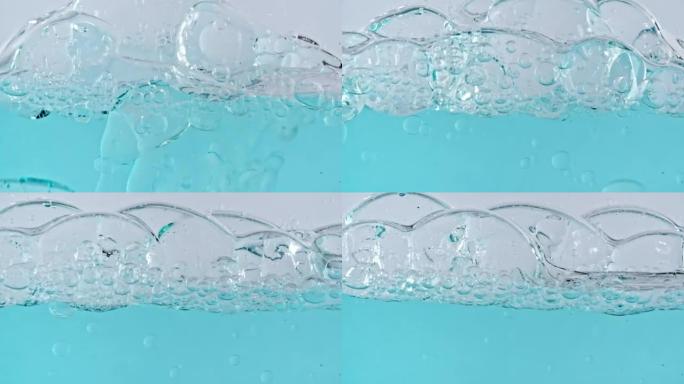 浅白色背景上上升的水中各种气泡的宏观拍摄。液体奶油凝胶透明化妆品样品质地与气泡。清洁和纯洁的概念。慢