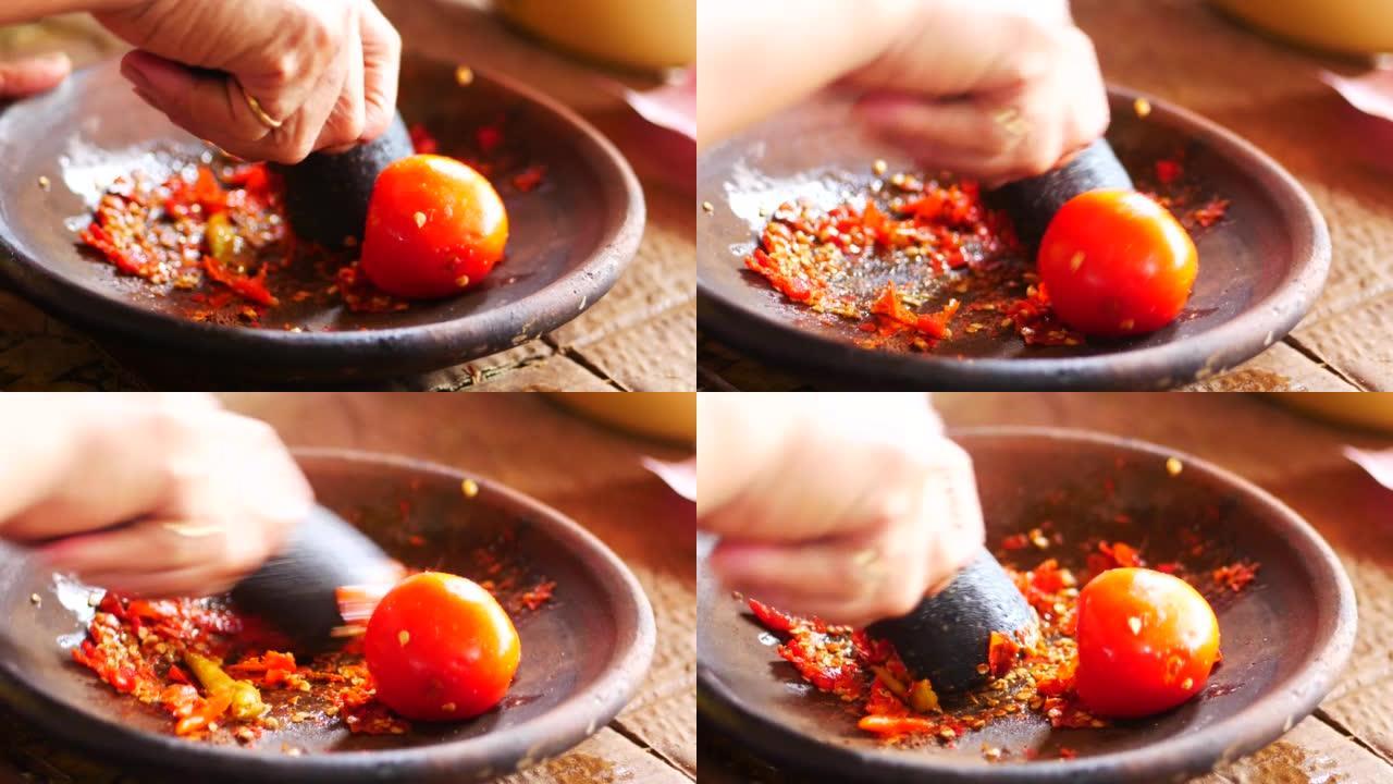 用凡人和研杵制作桑巴。Sambal是一种印尼辣椒酱或糊状物，通常由多种辣椒和次要成分的混合物制成。