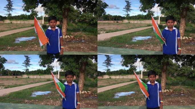 印度小男孩自豪地举着三色旗。印度的国旗，俗称三色旗，是由印度藏红花、印度白和印度绿组成的横矩形三色旗