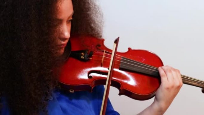 女孩小提琴家在家里演奏小提琴音乐会。特写。
