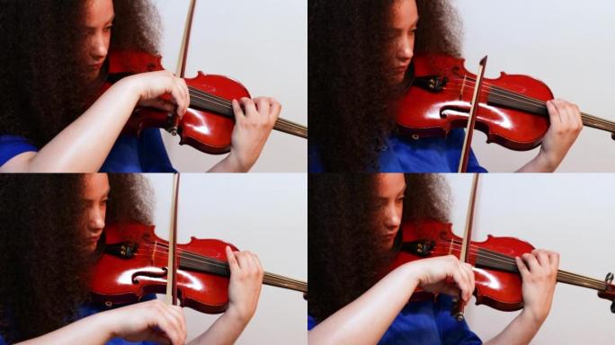 女孩小提琴家在家里演奏小提琴音乐会。特写。