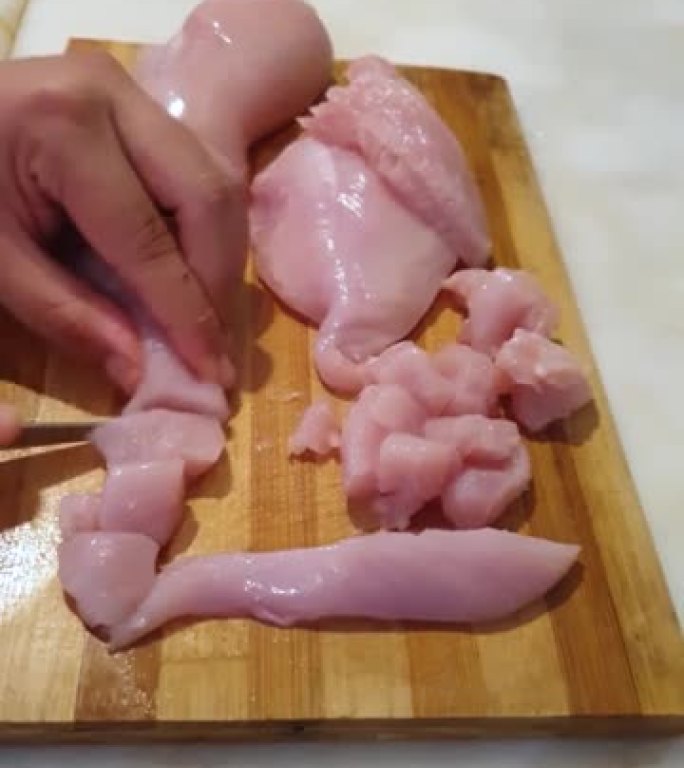 厨师将鸡胸肉切成薄片