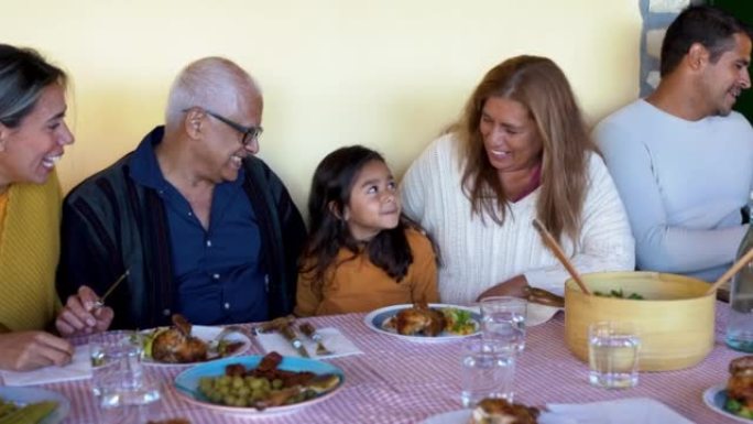 快乐的拉丁家庭在家里享受午餐 -- 祖父母、父母和孩子在一起玩得开心