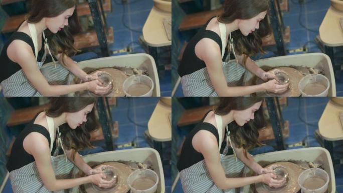 女工匠在纺纱机上用瓷土制作花瓶。