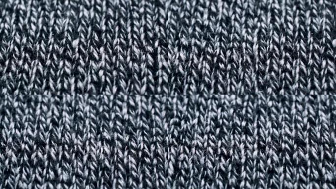 针织面料纹理中的灰色和白色线。特写细节毛衣面料背景。冬季时尚背景柔软羊毛纺织图案