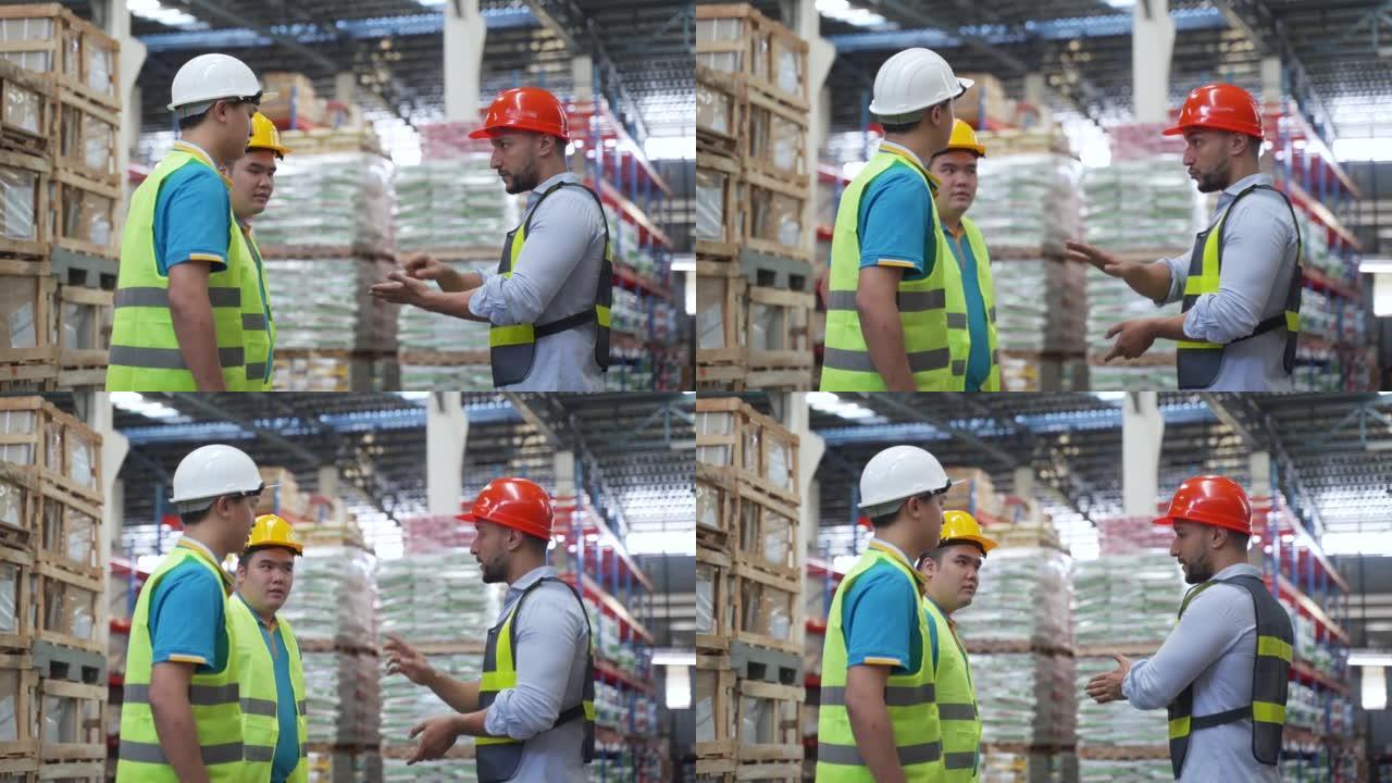 4K，大型仓库经理建议站在仓库中的两名职业安全员工穿着反光背心和保护性安全帽，并在早上培训工人。命令