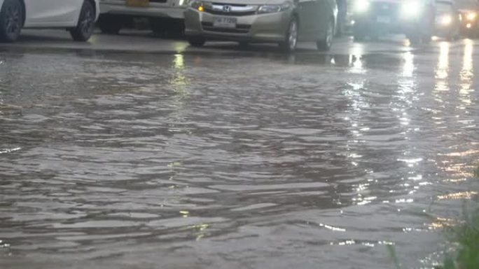 暴雨过后，汽车在洪水泛滥的道路上行驶。