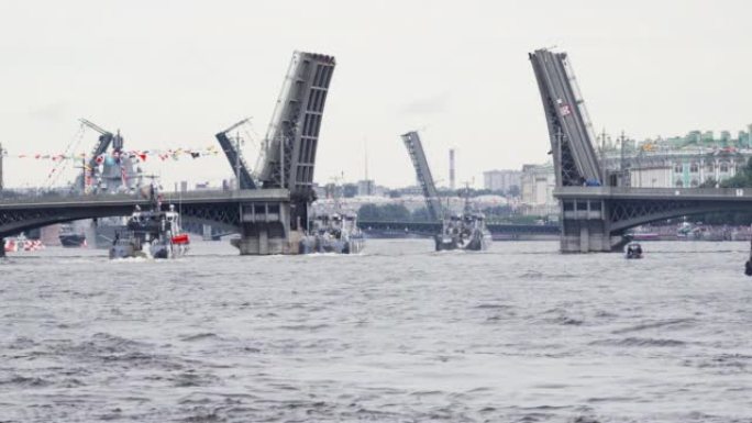 在晴天庆祝海军日的彩排时，许多军舰在开放的桥梁下沿着涅瓦河前进