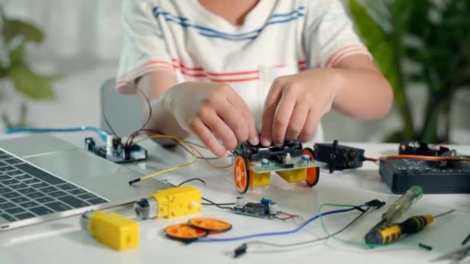 亚洲小男孩拼装板进入Arduino机器人汽车作业