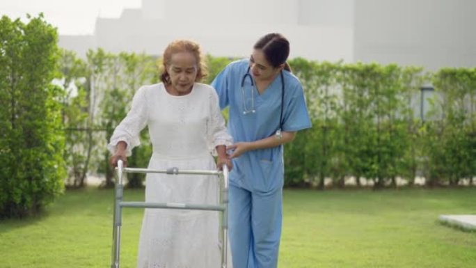 亚洲女性理疗师或看护人或护理人员对老年女性患者，帮助做物理治疗和支持在疗养院或医院练习拐杖走路。医院