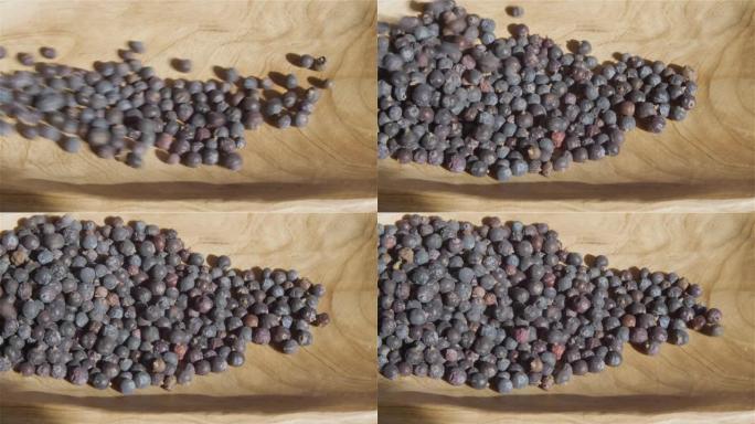 收集的杜松浆果掉入木碗中，Jupniperus communis