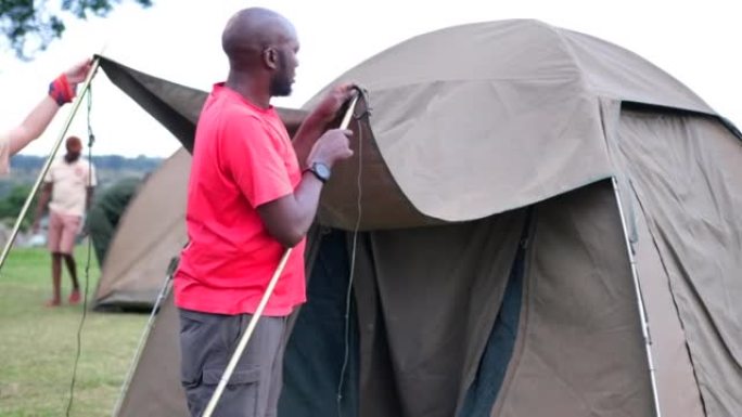 一个黑人和一个白人女孩助手搭起了帐篷，供游客露营。