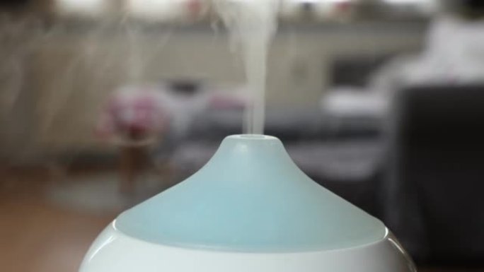 白色香薰油扩散器加湿器顶部的特写在家庭内部呼出香味雾
