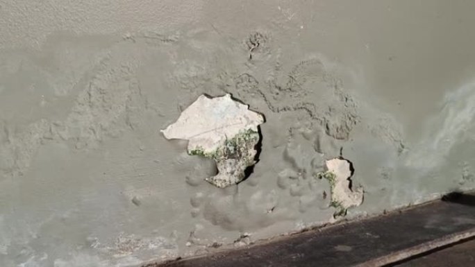 旧建筑的墙壁开裂，修复不良，油漆剥落。