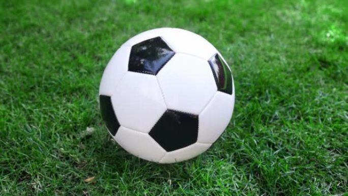 在绿草地上绕着足球足球旋转的摄像机。