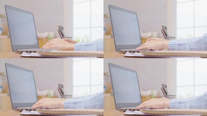 女商人用电脑笔记本电脑在键盘上打字的特写手。女人的手在家里的工作台上聊天或写文章。B滚动打字到计算机